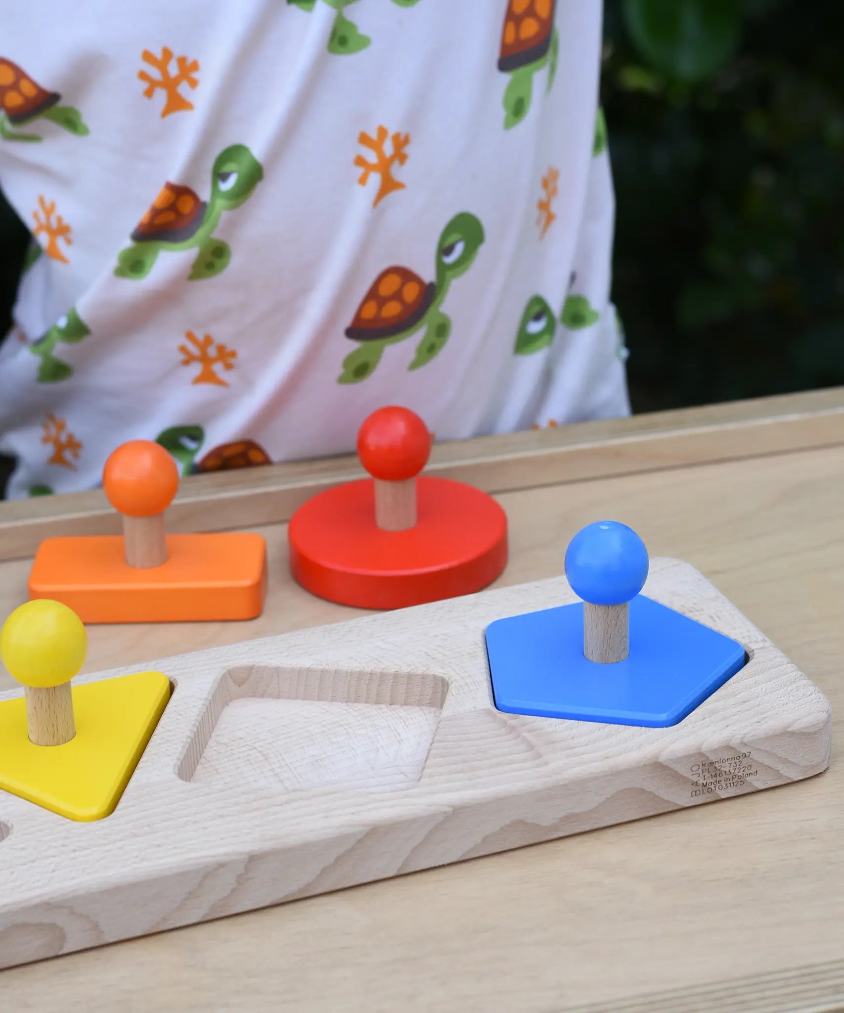 Bajo figures shapes sorting board placed on a Miri with some pieces taken out and placed besides the base frame.