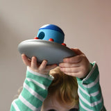 A child holding the Bajo Alien Flying Saucer above his head.