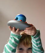 A child holding the Bajo Alien Flying Saucer above his head.