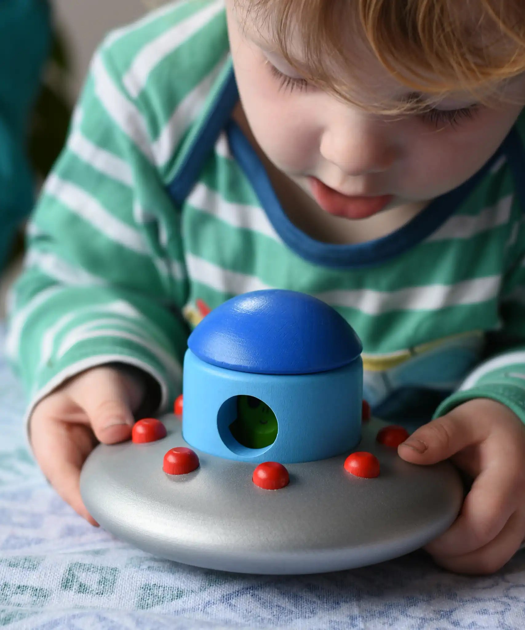 A child lifting up the Bajo Alien Flying Saucer set.