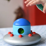 A child's hand reaching for the Bajo Alien Flying Saucer.