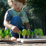 Child playing with Bajo's forest central park set on a stone surface 
