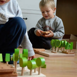 Children playing with Bajo's forest central park set on a wooden floor