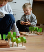 Children playing with Bajo's forest central park set on a wooden floor