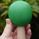 Large green sphere tree from the Bajo green forest tree set in a adult's hand.