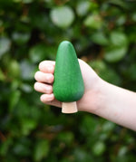 Large green conical tree from the Bajo green forest tree set in a child's hand.