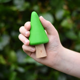Light green conical tree from the Bajo green forest tree set in a child's hand.