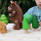 Child playing with the Bajo green forest tree set and Gruffalo and mouse character figures. 
