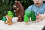 Child playing with the Bajo green forest tree set and Gruffalo and mouse character figures. 