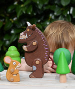 Child playing with the Bajo green forest tree set and the Gruffalo and mouse character figures. 

