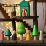 Bajo green forest tree set figures lined up next to Grapat animal crew wooden peg dolls. Magic Wood adventure playground in eh background. 