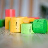 Bajo Fractions Set. A set of coloured wooden blocks marked with fractions on each block. These heirloom quality toys by Bajo are part of a wide range of wooden toys available here at Babipur.