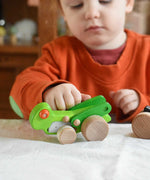A child playing with the Bajo green Grasshopper wooden toy. These heirloom quality toys by Bajo are part of a wide range of wooden toys available here at Babipur.