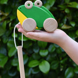 Bajo green double frogs pull along wooden toy in a child's hand. 