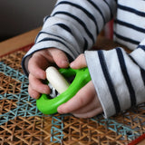 Child playing with the Bajo green Frog Rattle wooden baby toy in the Babipur playroom