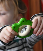 Bajo green Frog Rattle wooden baby in a child's hand in the Babipur playroom