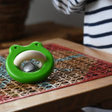 Bajo green Frog Rattle wooden baby toy placed on a rattan stool in the Babipur playroom,
