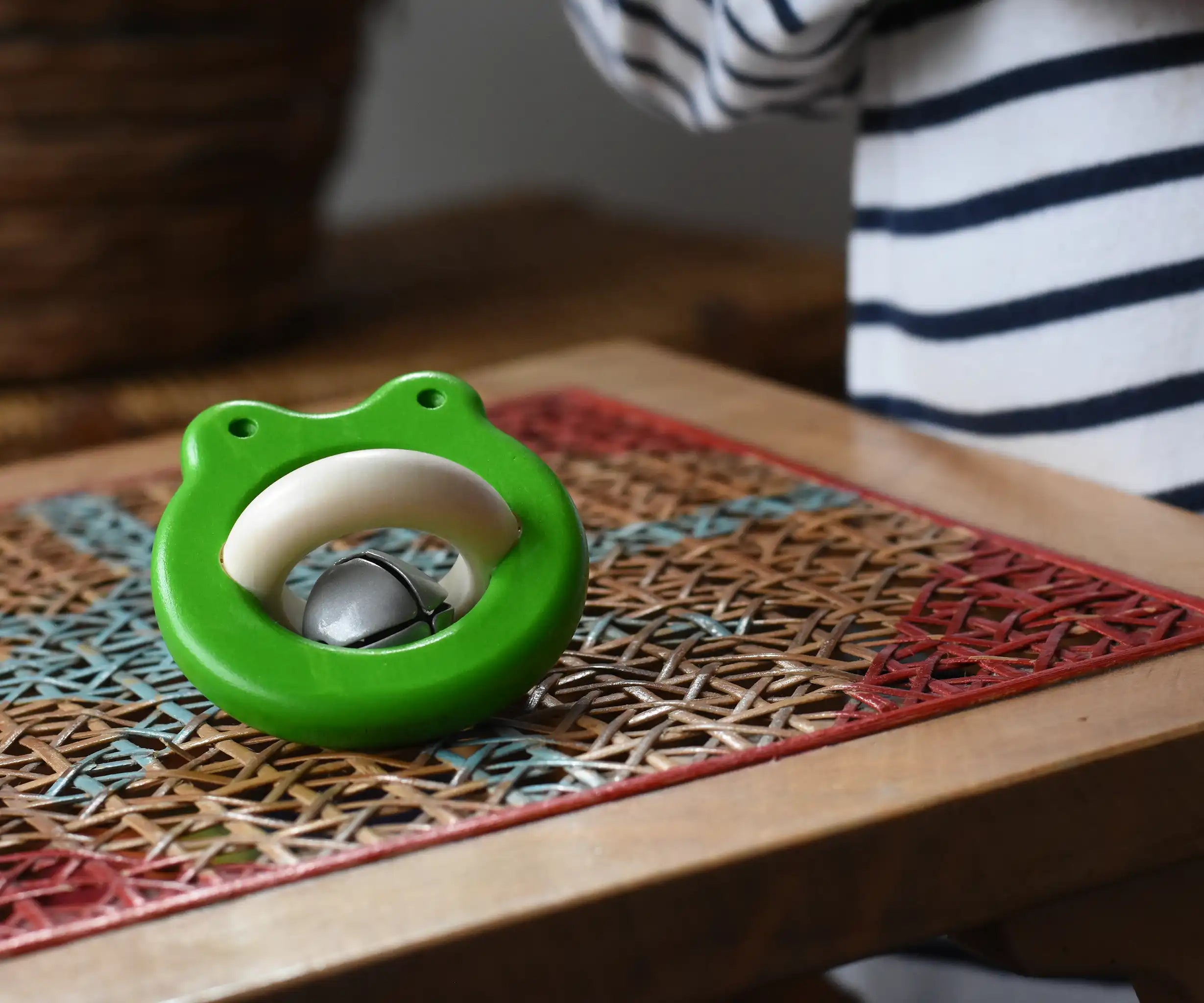 Bajo green Frog Rattle wooden baby toy placed on a rattan stool in the Babipur playroom,