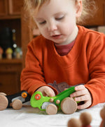 A child playing with the Bajo green Grasshopper wooden toy. These heirloom quality toys by Bajo are part of a wide range of wooden toys available here at Babipur.