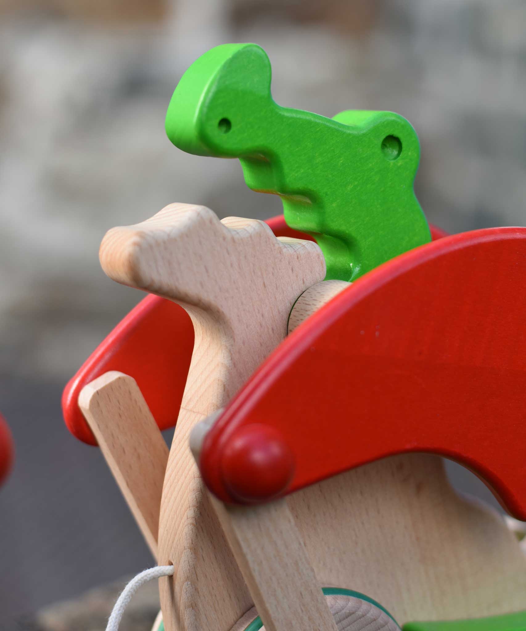 A close up of the head of the dragon's face of the Bajo green pull along dragon wooden toy. These heirloom quality toys by Bajo are part of a wide range of wooden toys available here at Babipur.