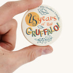 a close up of the back of the coin from the memory game on a cream background