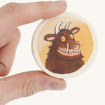 a close up of the coin from the memory game on a cream background
