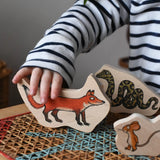 Child playing with the fox piece from the Bajo Gruffalo Character Puzzle in the Babipur playroom.