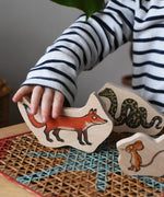 Child playing with the fox piece from the Bajo Gruffalo Character Puzzle in the Babipur playroom.