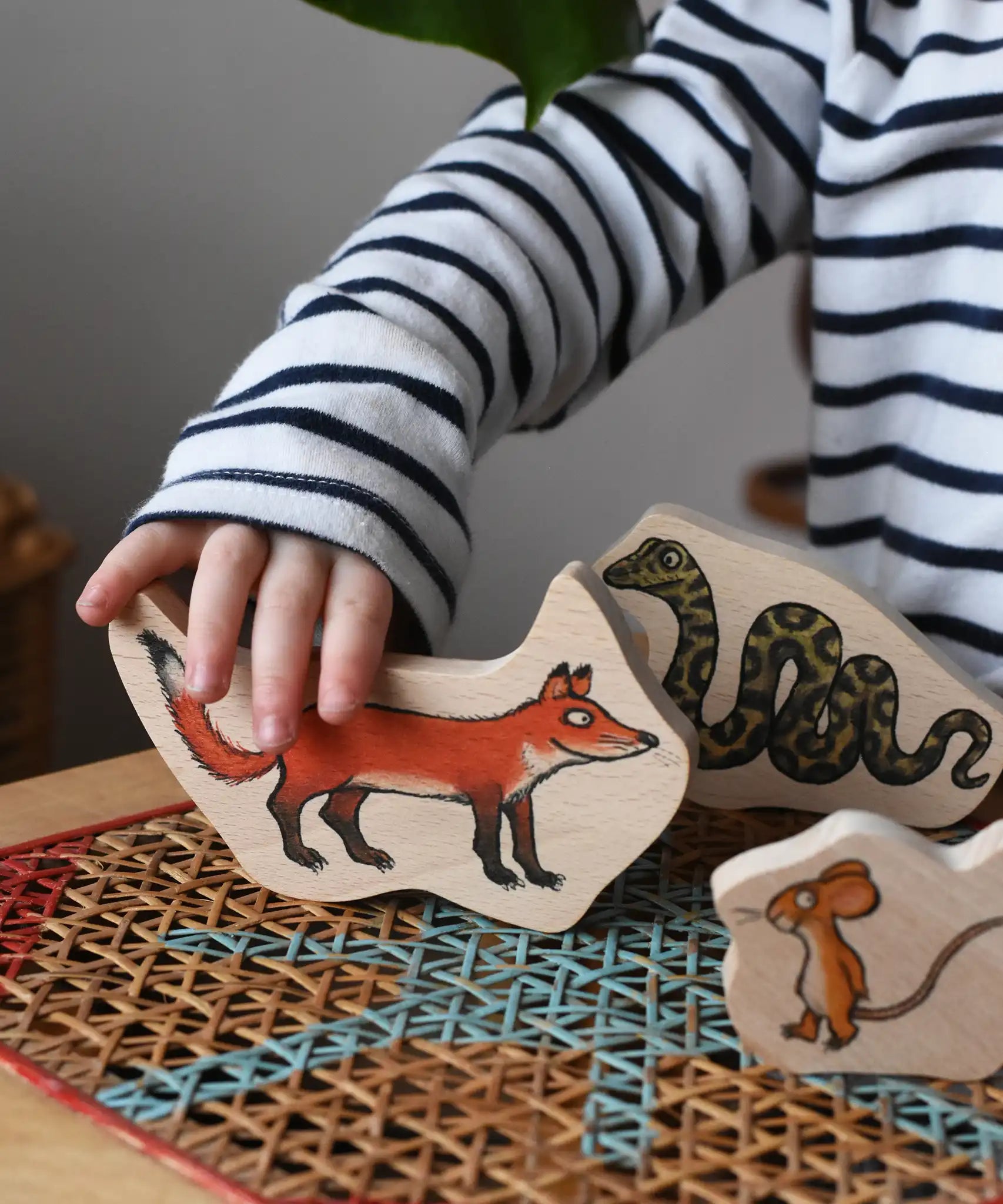 Child playing with the fox piece from the Bajo Gruffalo Character Puzzle in the Babipur playroom.