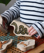 Child playing with the snake piece from the Bajo Gruffalo Character Puzzle in the Babipur playroom.