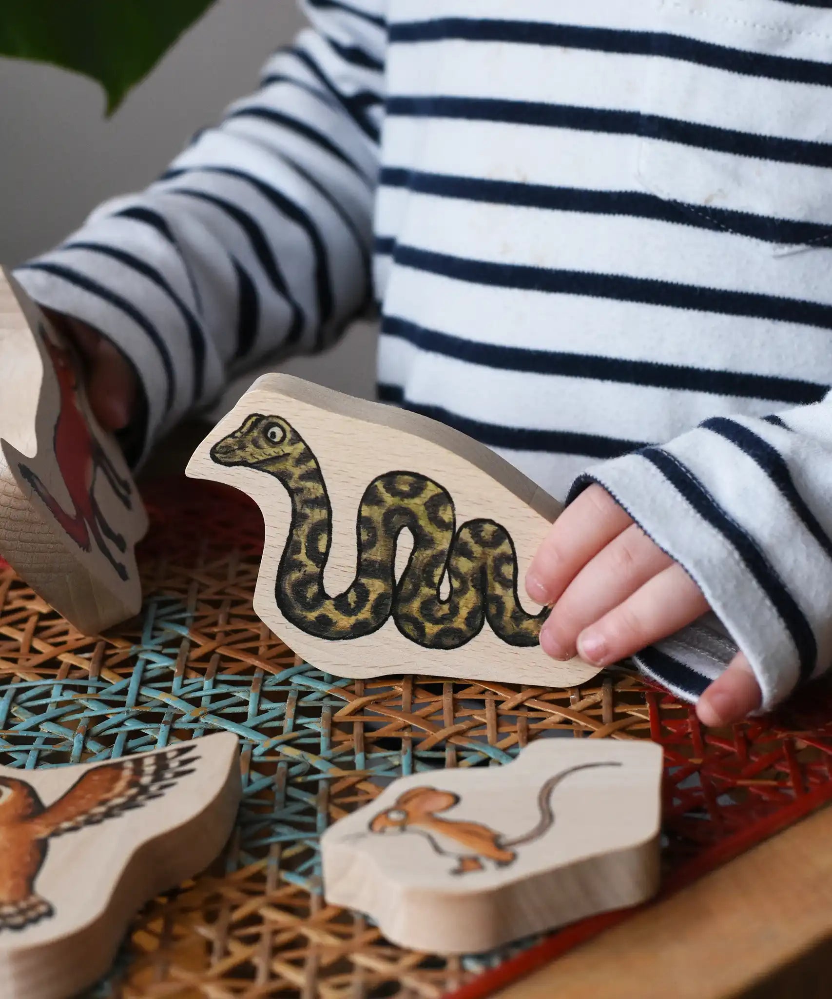 Child playing with the snake piece from the Bajo Gruffalo Character Puzzle in the Babipur playroom.