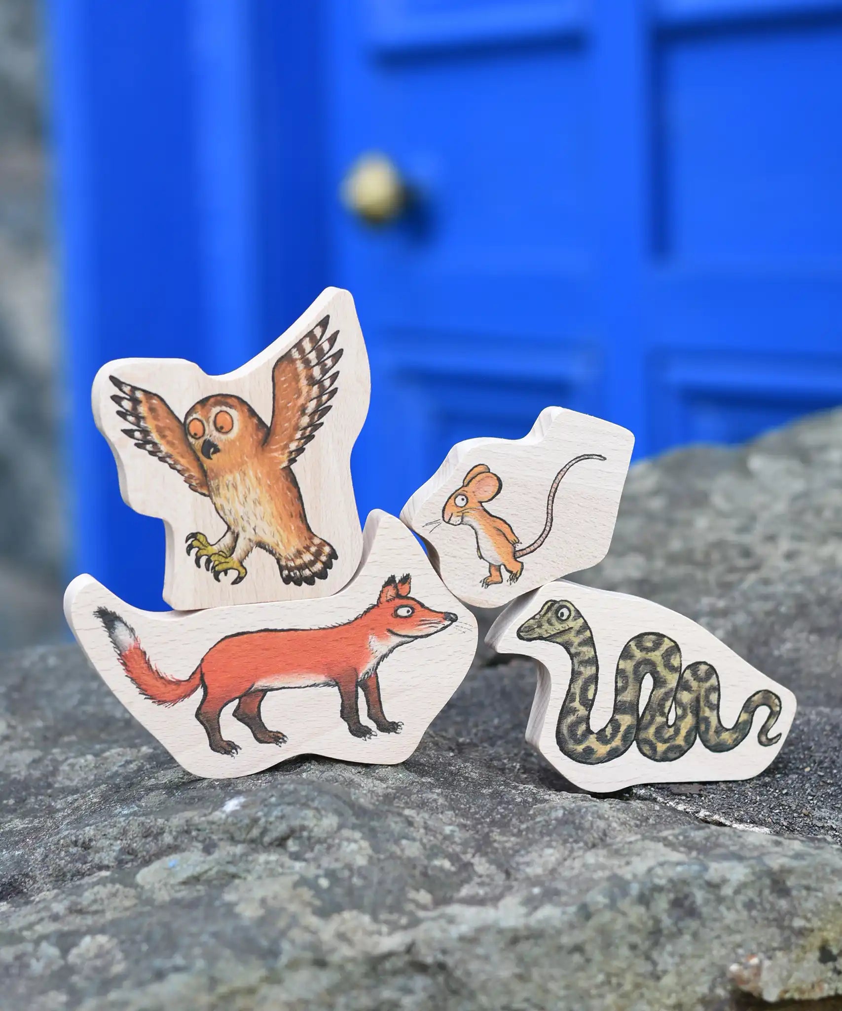 Bajo Gruffalo Character Puzzle pieces placed on a stone wall outdoors. 