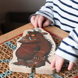 Child playing with the fox piece from the Bajo Gruffalo Character Puzzle in the Babipur playroom.