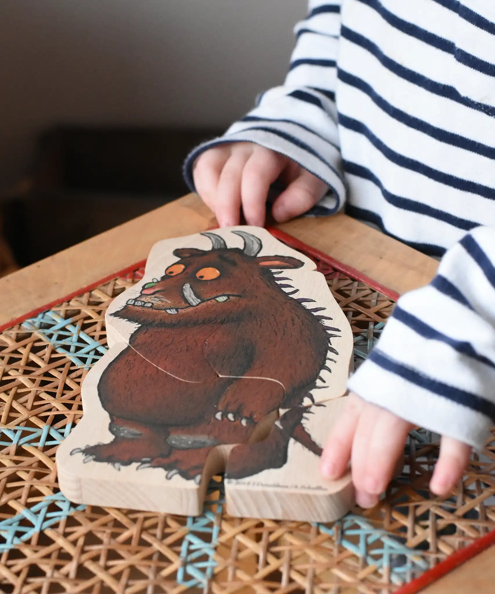 Child playing with the fox piece from the Bajo Gruffalo Character Puzzle in the Babipur playroom.