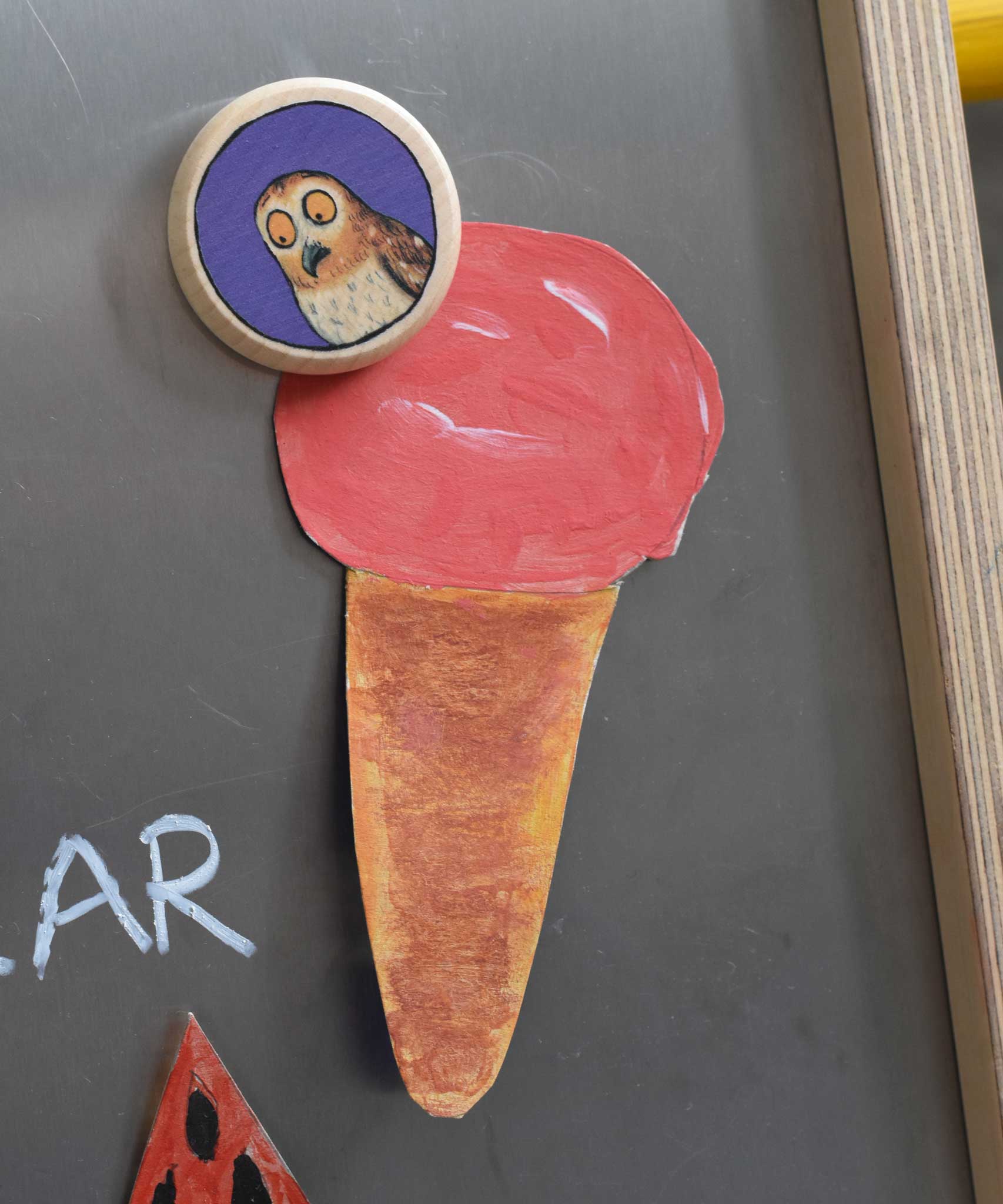 A close up of a Bajo gruffalo owl magnet stuck onto a Triclimb biri board. These magnets are part of a range of Bajo wooden toys available at Babipur. 