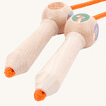 A close up of the wooden gruffalo skipping rope with orange rope on a cream background