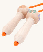 A close up of the wooden gruffalo skipping rope with orange rope on a cream background