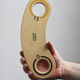 A close up of an adult's hand holding up a piece of the base from the Bajo Fellow Hoopla Game Set. A traditional style wooden game set that can be used for hoopla and skittles. These heirloom quality toys by Bajo are part of a wide range of wooden toys available here at Babipur.