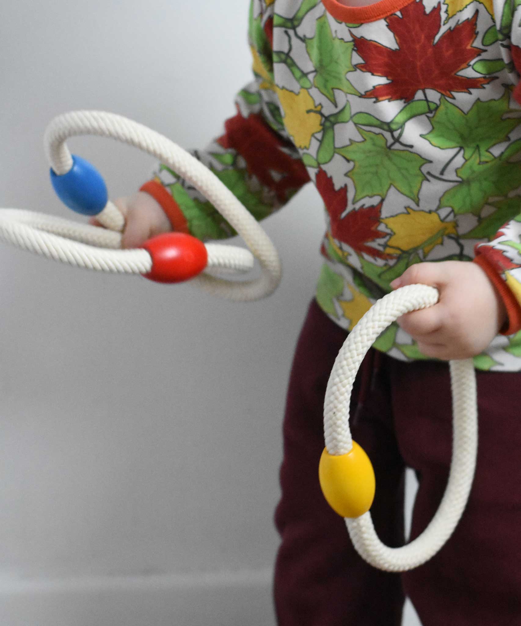 A close up of a child holding the rope hoops from the Bajo Fellow Hoopla Game Set. A traditional style wooden game set that can be used for hoopla and skittles. These heirloom quality toys by Bajo are part of a wide range of wooden toys available here at Babipur.