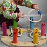 A young child playing with the Bajo Fellow Hoopla Game Set, set up as hoopla. A traditional style wooden game set that can be used for hoopla and skittles. These heirloom quality toys by Bajo are part of a wide range of wooden toys available here at Babipur.