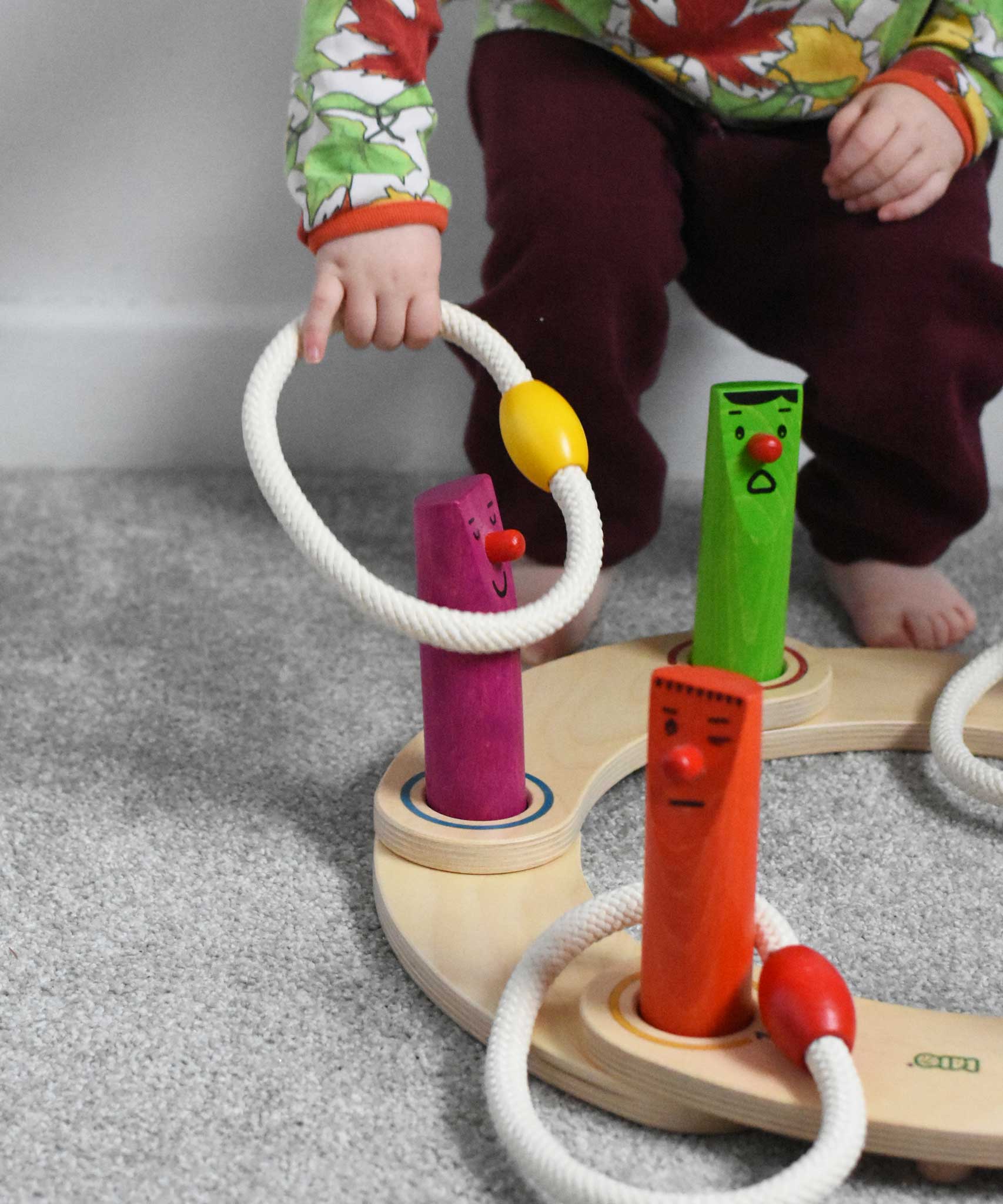 A young child playing with the Bajo Fellow Hoopla Game Set. A traditional style wooden game set that can be used for hoopla and skittles. These heirloom quality toys by Bajo are part of a wide range of wooden toys available here at Babipur.