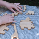 Child's hand slotting the animal shaped pieces from the Bajo jungle puzzle back together.