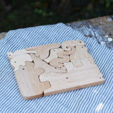 Bajo jungle puzzle shown on the natural wood side. Puzzle is made up of different animal shaped pieces.