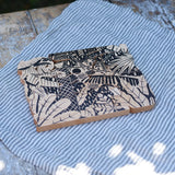 Bajo jungle puzzle shown on the black patterned side. Puzzle is made up of different animal shaped pieces.