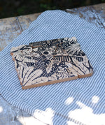 Bajo jungle puzzle shown on the black patterned side. Puzzle is made up of different animal shaped pieces.