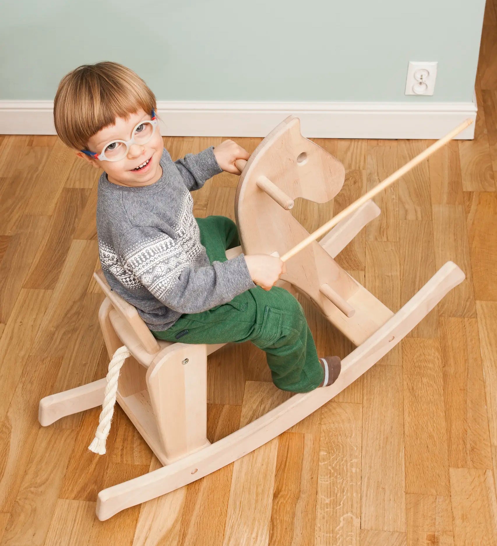 Child riding on the Bajo wooden rocking horse