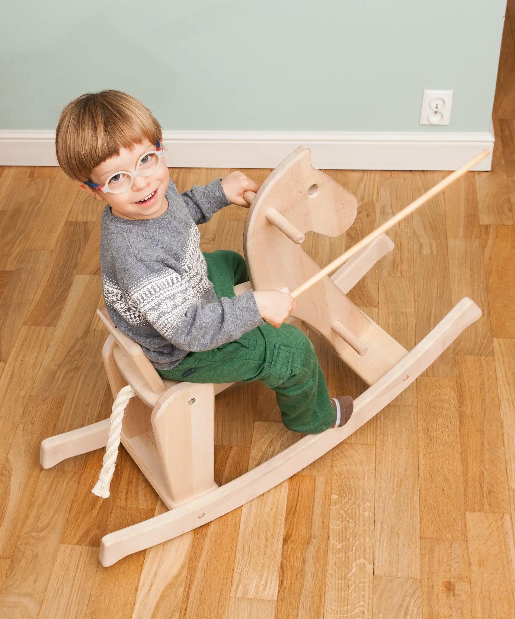 Child riding on the Bajo wooden rocking horse