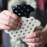 Bajo wooden lacing sheep and lamb toy shown with the laces taken out in a child's hands.