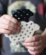 Bajo wooden lacing sheep and lamb toy shown with the laces taken out in a child's hands.