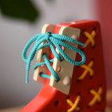 Close up of the blue laces tied up on the Bajo red lacing shoe.